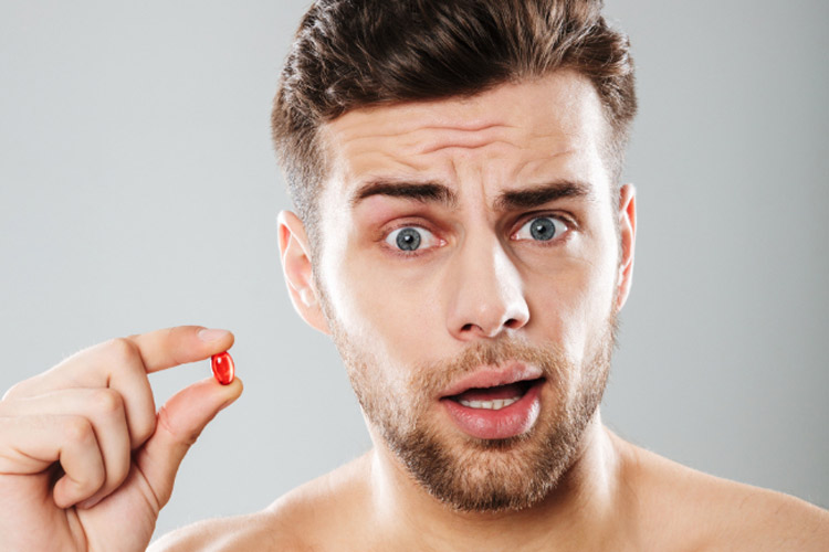 Mann mit Supplement in der Hand für dichtes Haar